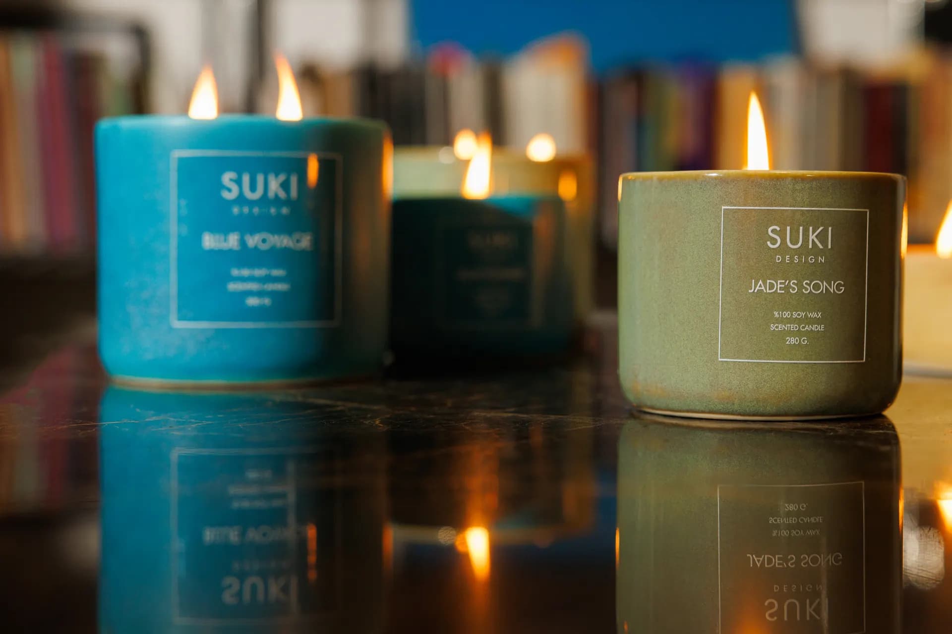 Product-led editorial image of Suki Design candles on a reflective surface